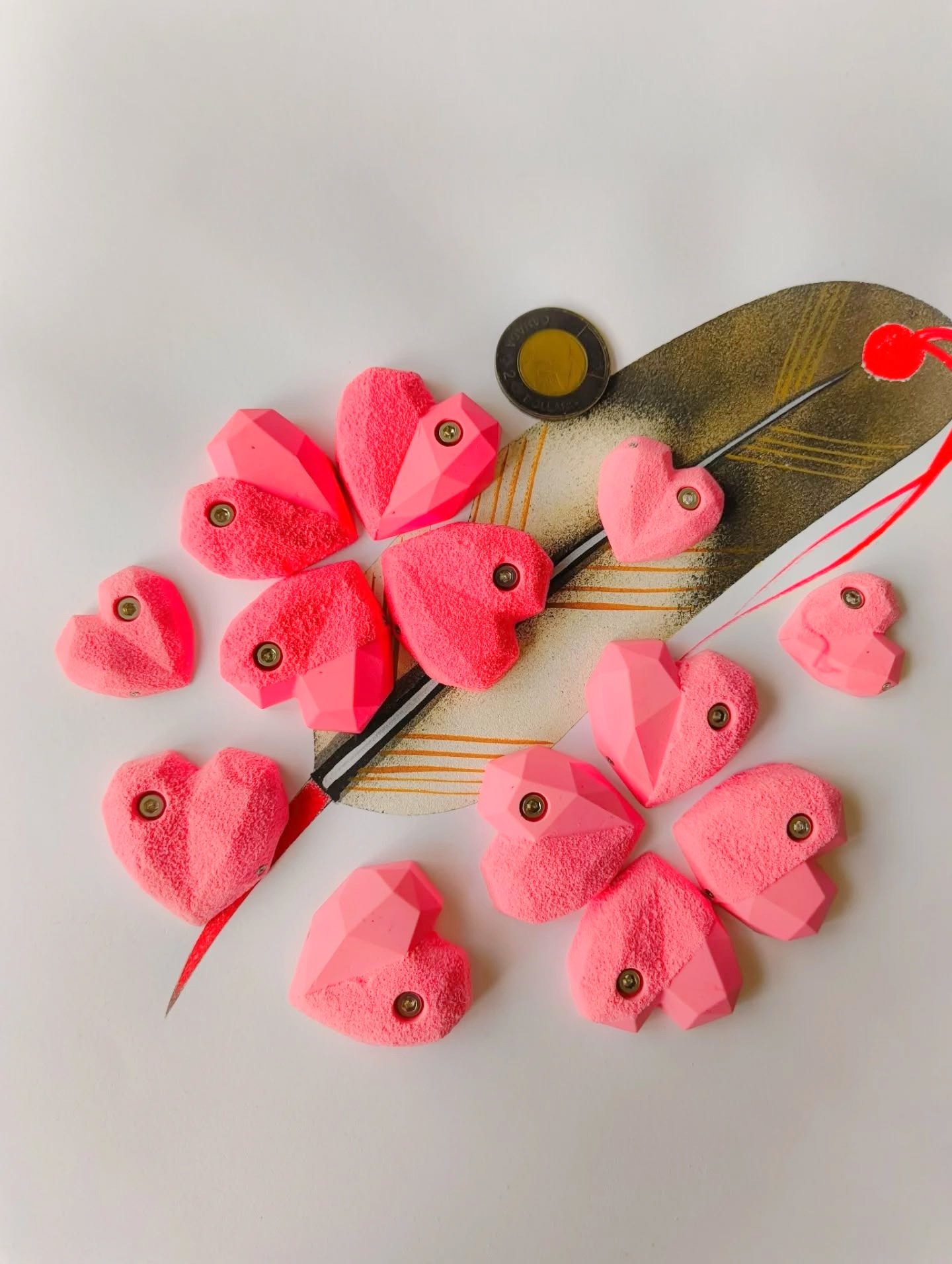 Pink heart-shaped miniature holds arranged around a climbing brush