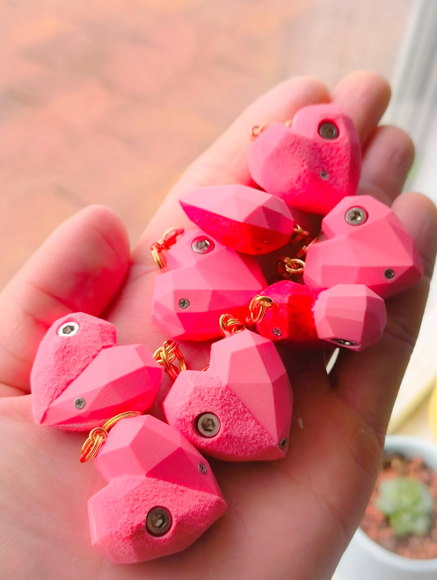 Collection of pink heart-shaped climbing hold keychains