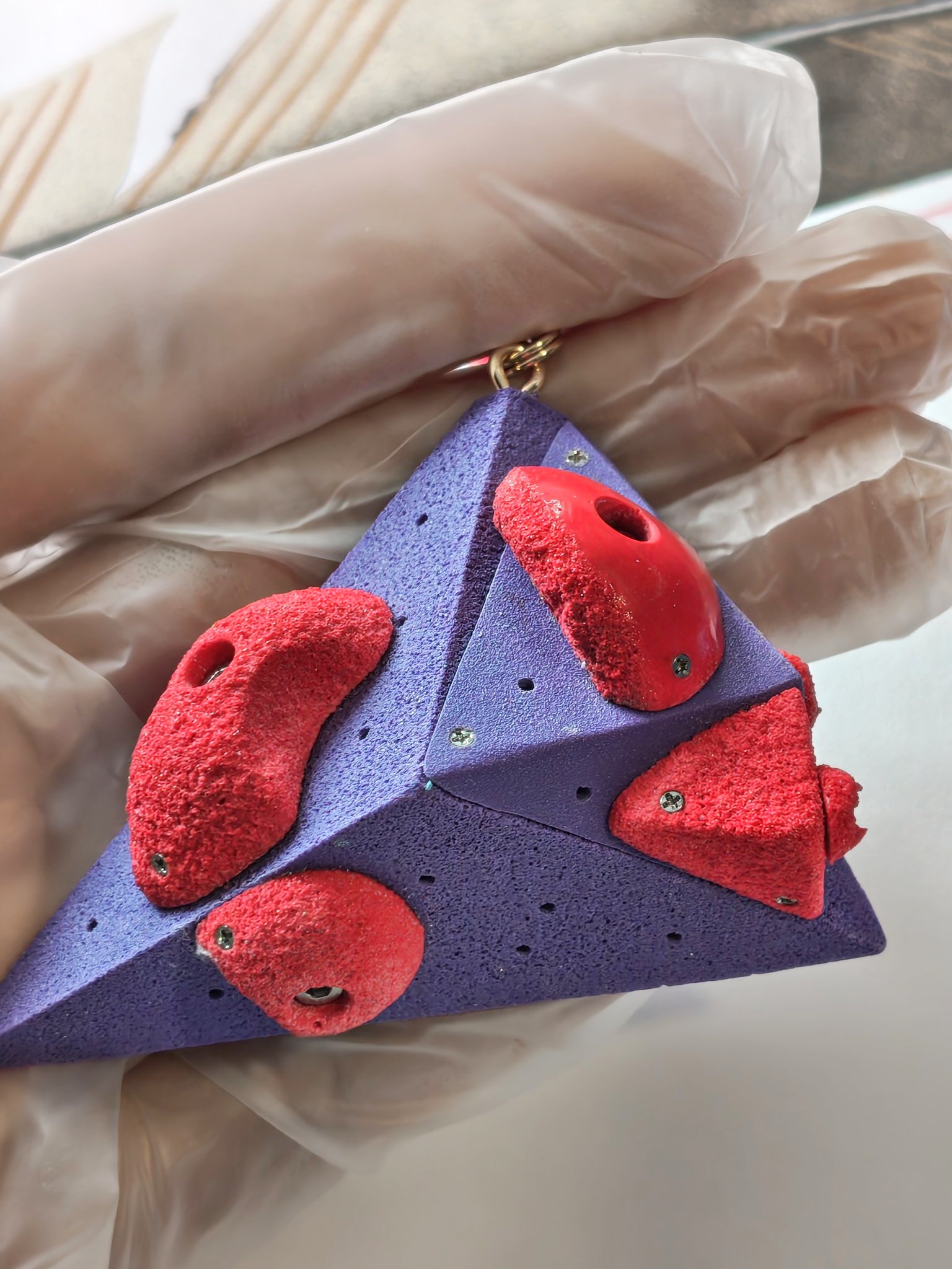 Red holds on a purple triangular miniature volume
